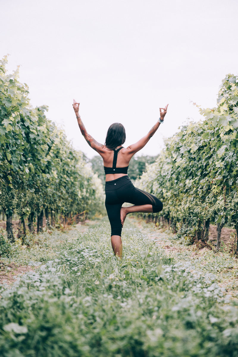 Female in Yoga pose in a vineyard. Bright and sunny, yet calming and cooling aesthetic. Stand true in your Innate Self, Listen to your Innate Intelligence. Taking time of self-care.